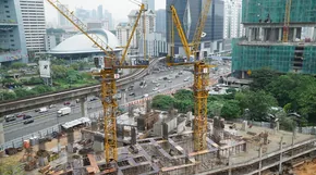 Tower cranes over a large building construction site in a city